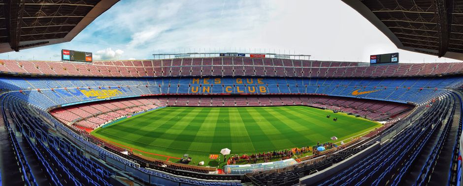 Una vista panorámica del icónico estadio Camp Nou, hogar del FC Barcelona, con graderías vacías.