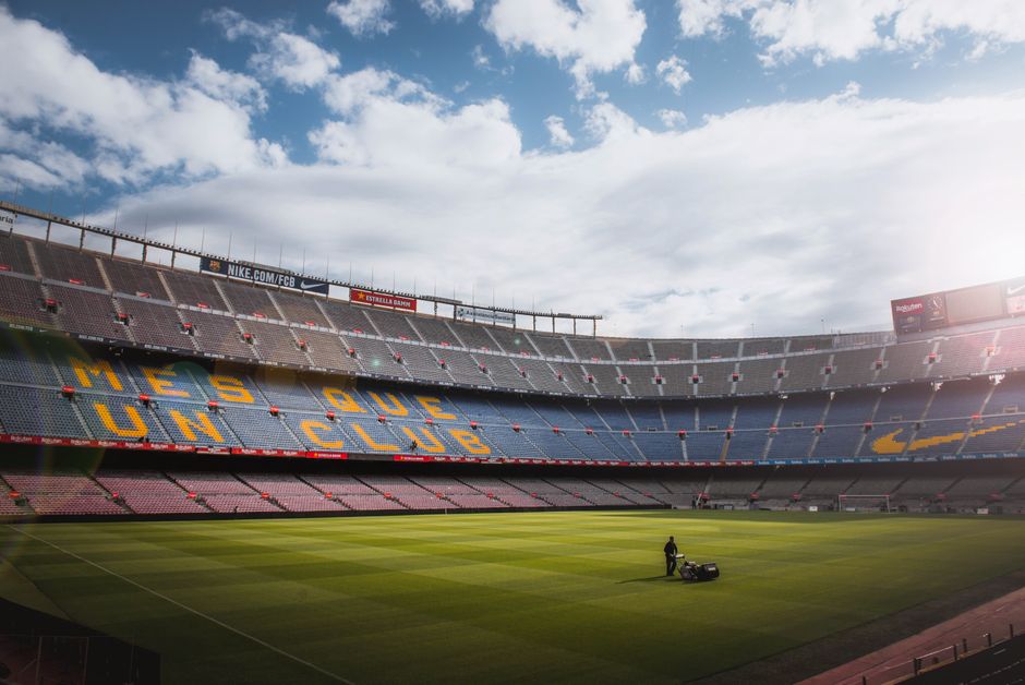 Un vibrante estadio de fútbol con un bien cuidado campo de hierba bajo un cielo brillante, mostrando su arquitectura icónica.