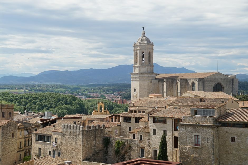 Captura de la arquitectura histórica de Girona con la icónica catedral sobre un fondo montañoso.