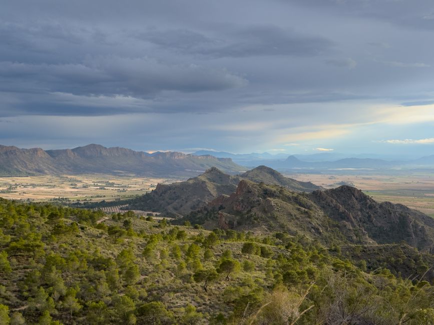 Vista escénica de montañas verdes bajo un cielo nublado, mostrando la belleza y tranquilidad de la naturaleza.