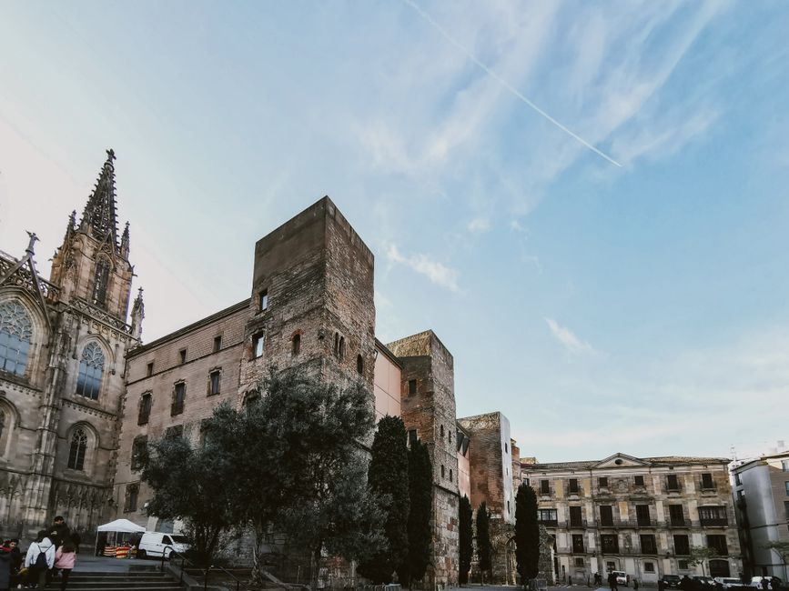 Arquitectura gótica histórica en el casco antiguo de Barcelona con cielo azul claro.