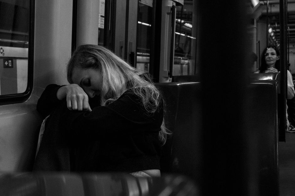Una fotografía espontánea en blanco y negro que captura la soledad emocional en el metro de Barcelona.