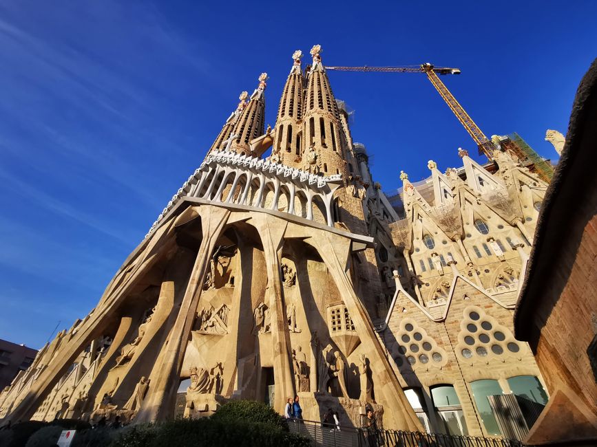 Una vista impresionante de la icónica basílica de la Sagrada Familia en Barcelona con un cielo azul claro.