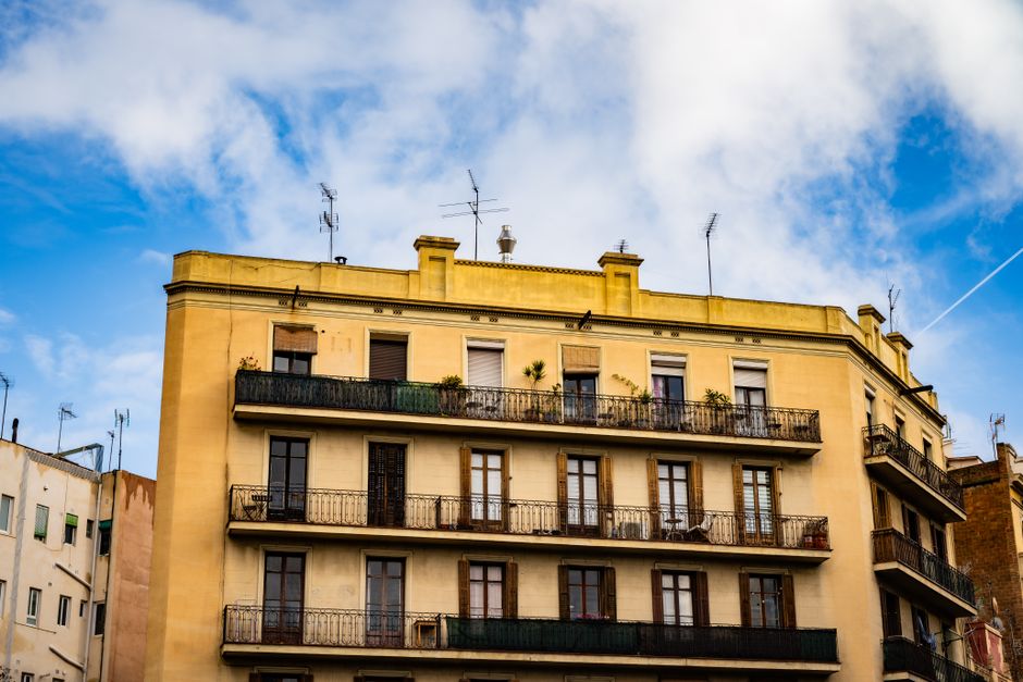 Encantadora vista de un edificio de apartamentos histórico en Barcelona, que muestra una arquitectura clásica contra un cielo azul.