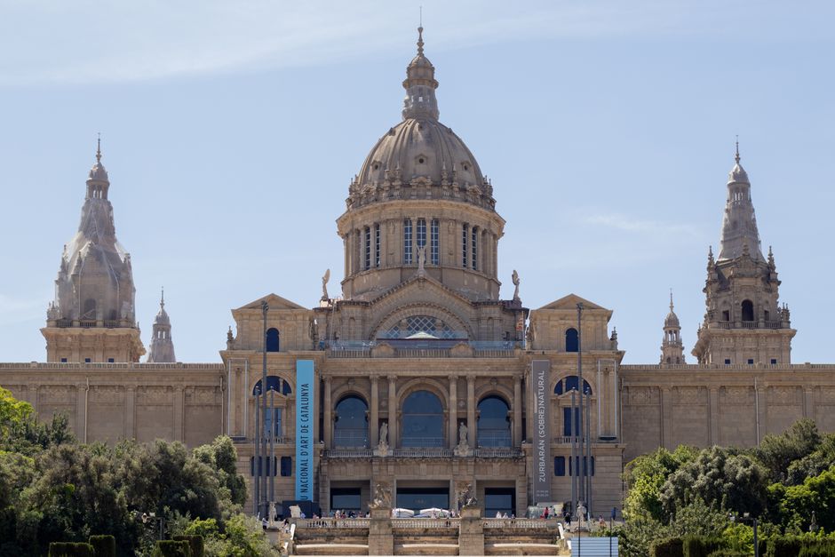 Vista frontal del Museo Nacional de Arte de Cataluña que muestra su grandiosa arquitectura bajo un cielo despejado.
