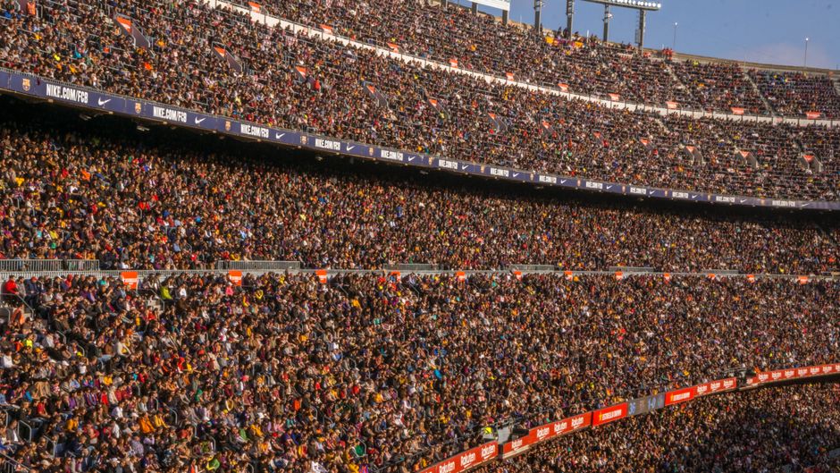 Una multitud vibrante llena el estadio Camp Nou, Barcelona durante un partido de fútbol.