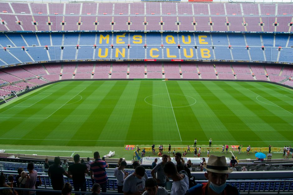 Vista aérea del Estadio Camp Nou en Barcelona, mostrando los icónicos asientos de 'Més Que Un Club' a la luz del día.