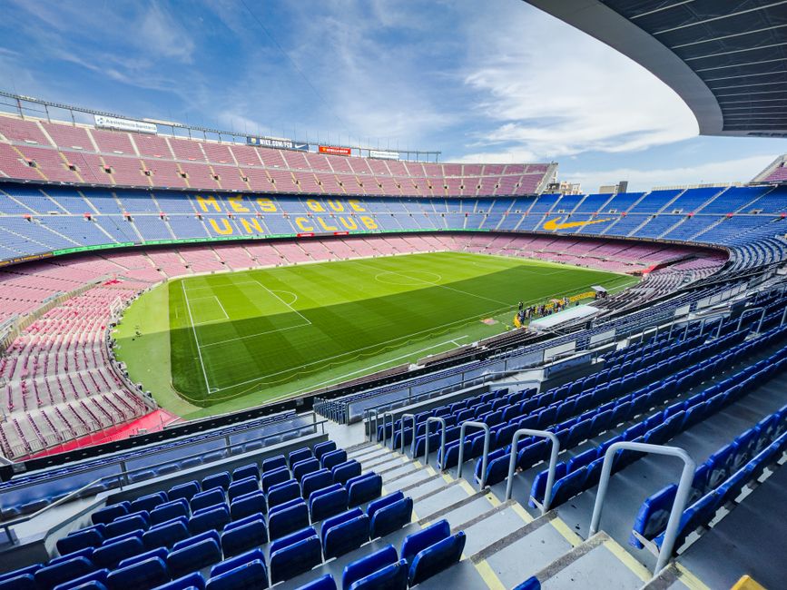 Vista gran angular del icónico Estadio Camp Nou en Barcelona, España, con sus asientos vibrantes y campo verde.