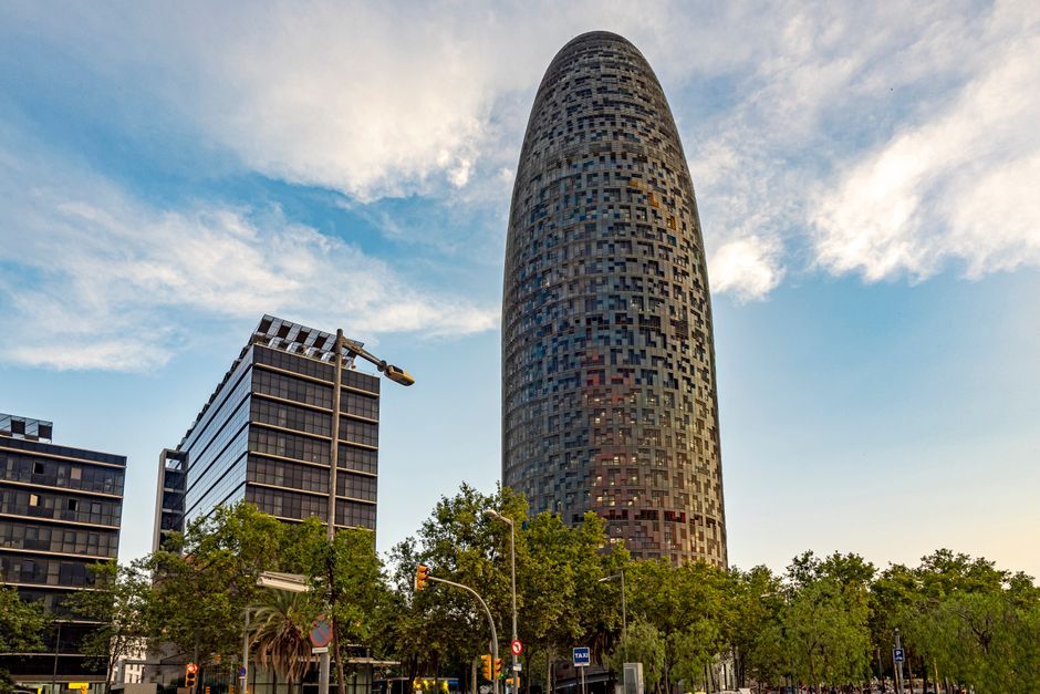 Arquitectura moderna de la Torre Glòries en Barcelona con fondo de cielo azul.