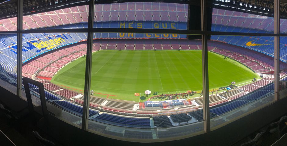Amplia vista del estadio Camp Nou que muestra su vasta capacidad de asientos y el césped verde.