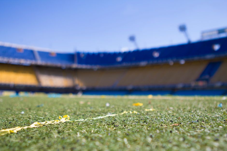Vista en primer plano de un vibrante campo de fútbol en un estadio soleado de Buenos Aires, perfecto para los aficionados a los deportes.
