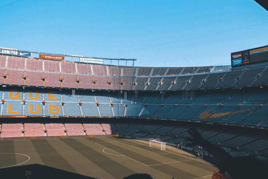 Toma amplia del icónico estadio Camp Nou en Barcelona, mostrando asientos vacíos y el campo de fútbol.