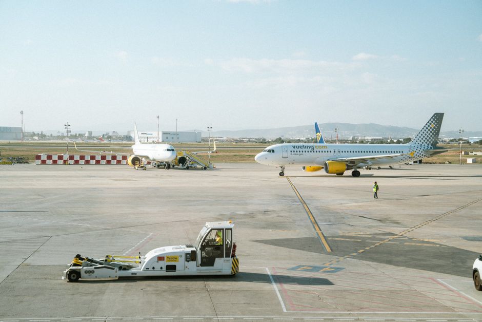 Avión de Vueling Airlines rodando por la pista de un aeropuerto con cielo despejado.