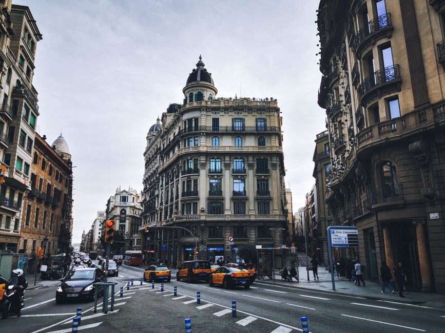 Vista histórica de la intersección urbana de Barcelona con arquitectura tradicional y tráfico.