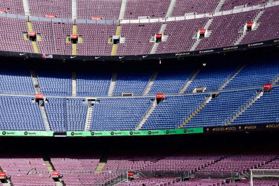 Vista en gran angular de las gradas vacías del Estadio Camp Nou en Barcelona que muestra colores vibrantes en los asientos.