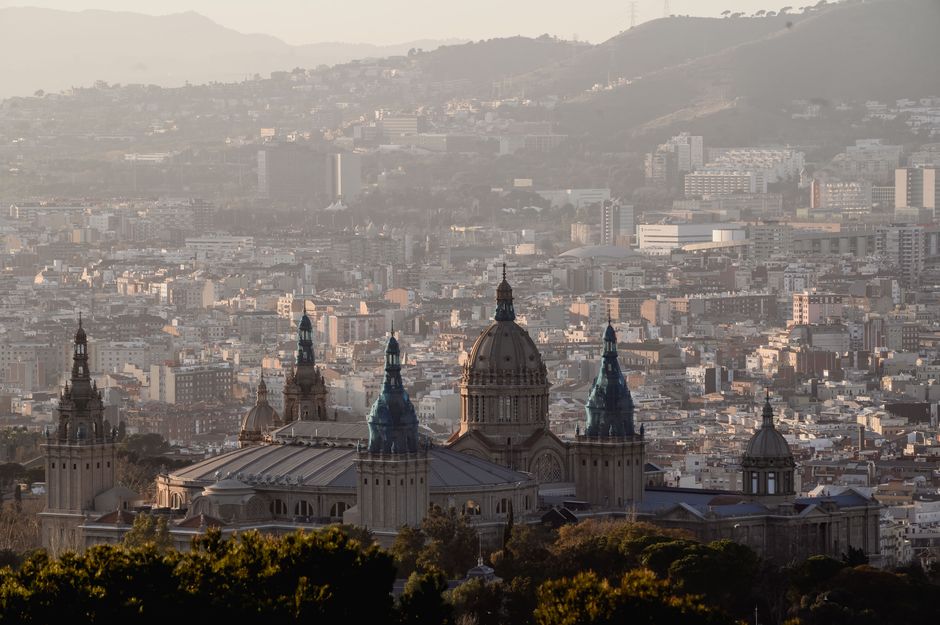 Vista escénica de Barcelona con el Museo Nacional de Arte en primer plano y el paisaje urbano al fondo.