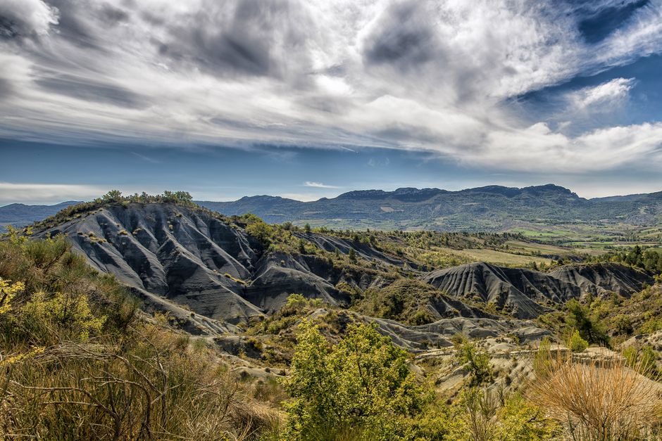 Paisaje escénico con colinas onduladas bajo un impresionante cielo lleno de nubes, perfecto para imágenes de viajes por la naturaleza.