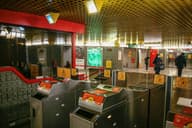 Torniquetes en una concurrida estación de metro de Milán, mostrando la infraestructura de transporte público.