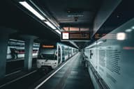 Un elegante tren de metro en una estación subterránea iluminada, que muestra el transporte ferroviario moderno.