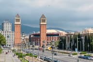 Las icónicas Torres Venezianas se alzan en medio del vibrante paisaje urbano de Barcelona.