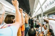 Viajeros apiñados en un tren de metro, capturando la vida agitada del transporte público urbano.