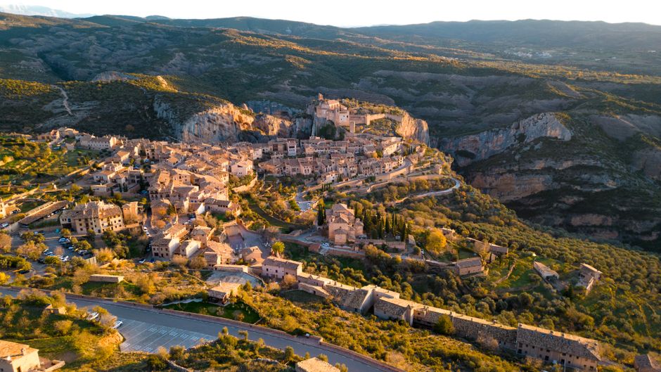 Impresionante vista aérea de la villa de Alquézar, situada en las colinas de Aragón, España, que muestra la arquitectura histórica y el paisaje escénico.