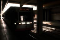 Una vista oscura y atmosférica de un tren de metro llegando a una plataforma de estación cubierta.