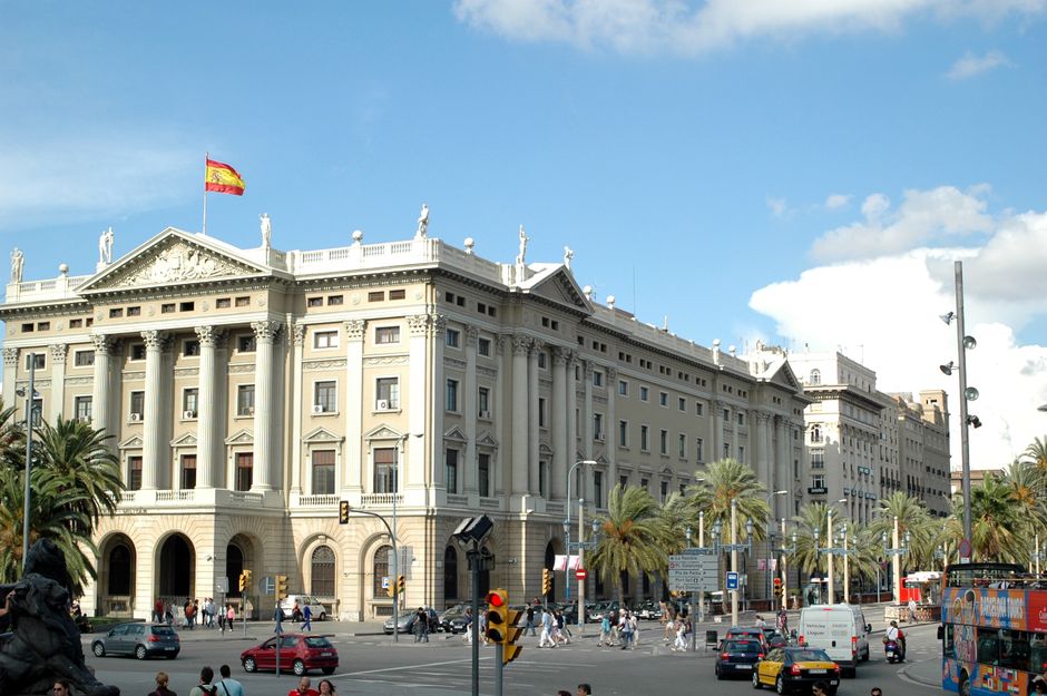 Edificio neoclásico en Barcelona, que muestra la arquitectura española con una animada escena callejera.