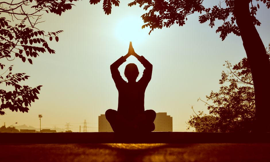 Persona haciendo yoga al amanecer